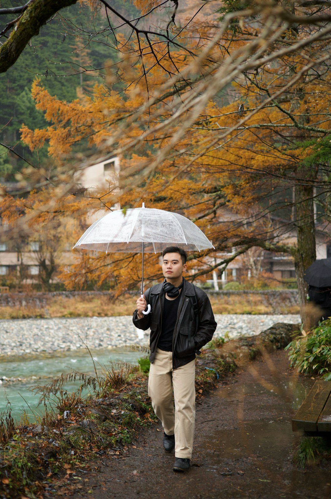 梅雨の雨の中傘をさして山道を歩く