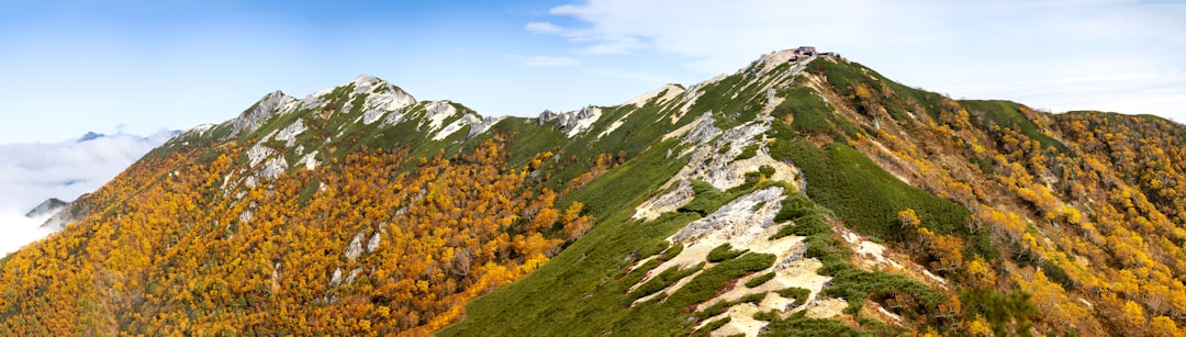 秋の紅葉に囲まれた岩場の登山道