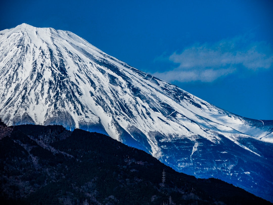 青空を背景に雪をまとった富士山