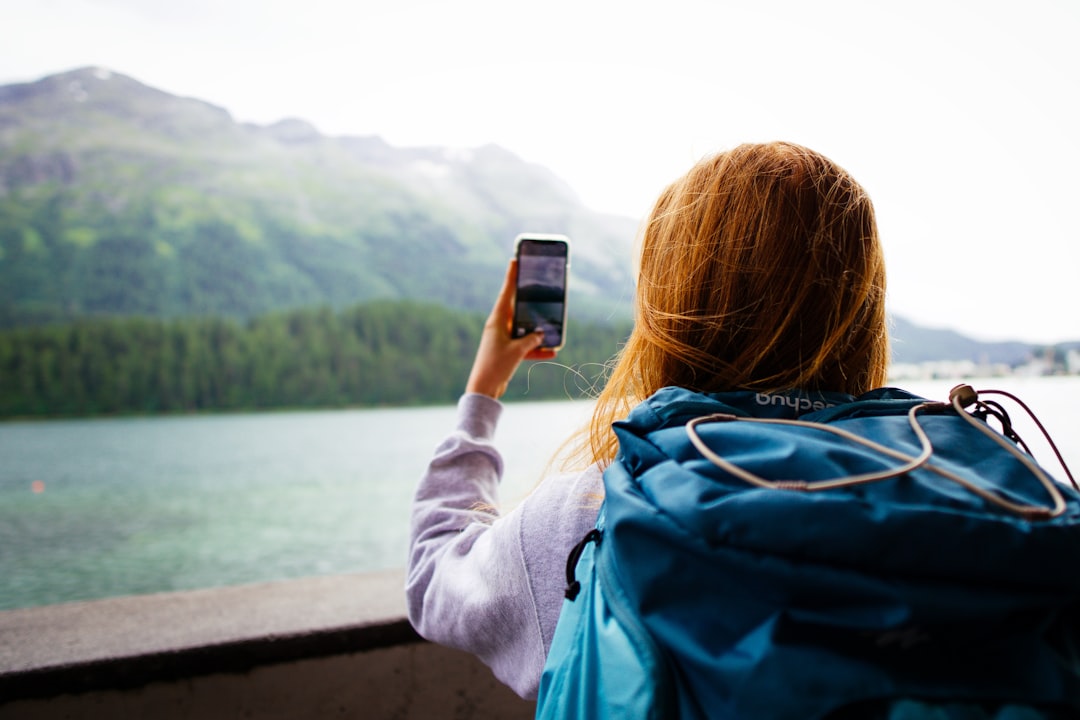 山の稜線でスマートフォンを使う登山者