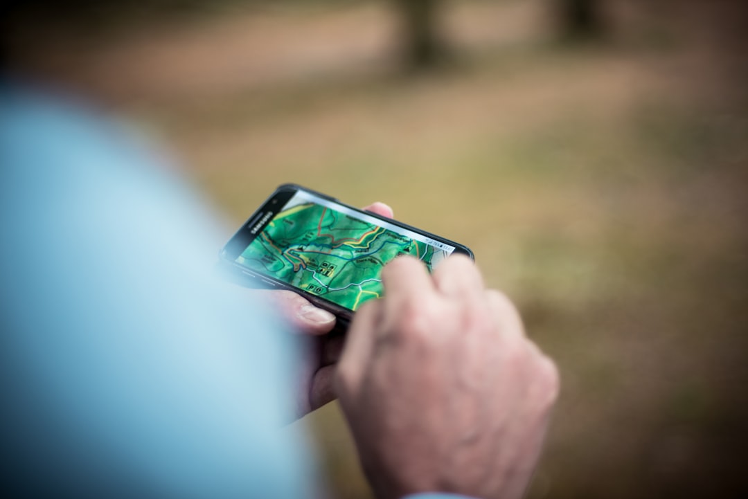 山道でスマートフォンの地図を確認する登山者