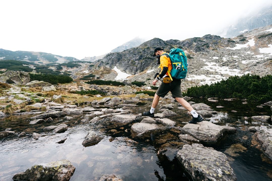 レインウェアを着て登山道を歩くハイカー