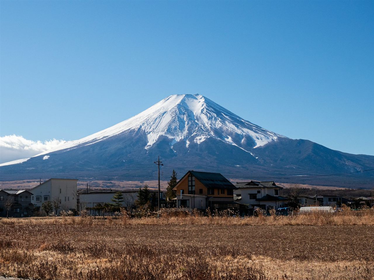稜線越しに見える雪をまとった富士山