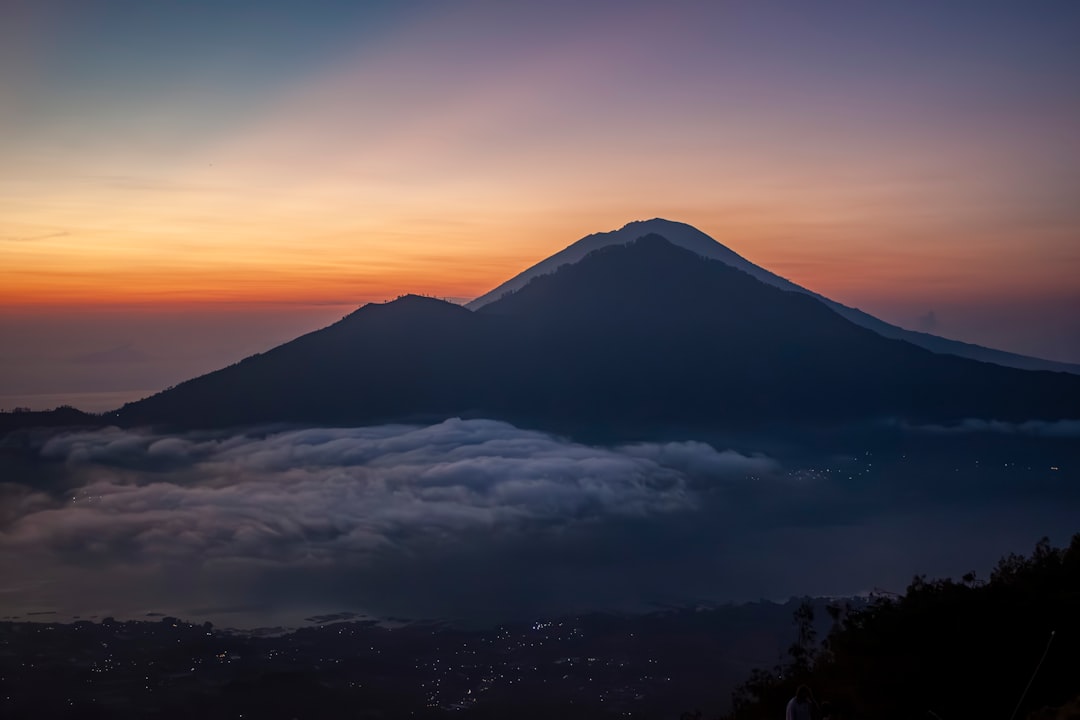 山の稜線から見る朝焼けの空のイメージ
