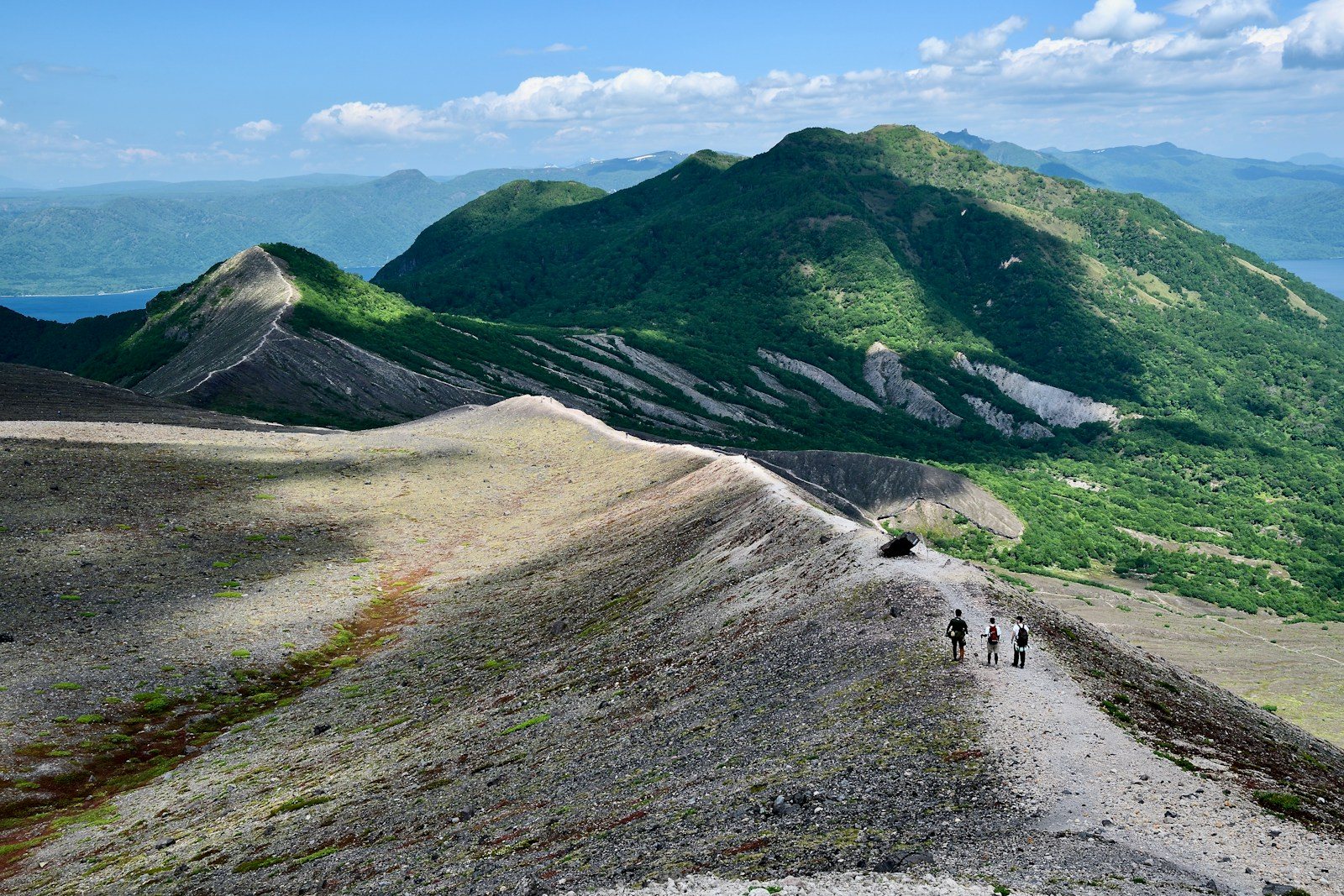 夏の火山性高山を登る登山者