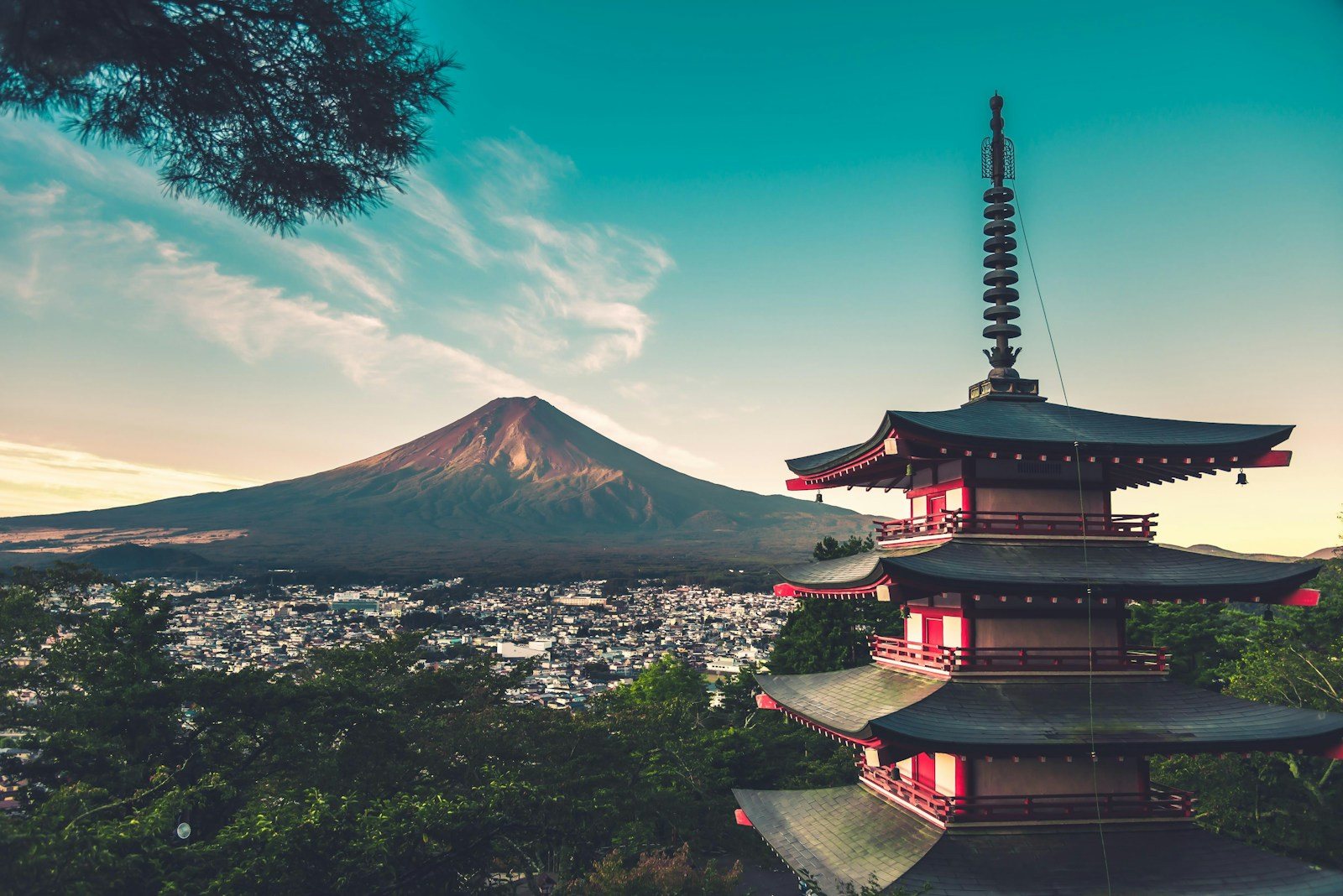 街並みの向こうに富士山を望む朱色の塔