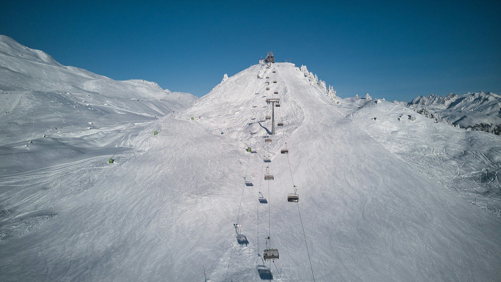 雪山の斜面に伸びるリフトのライン