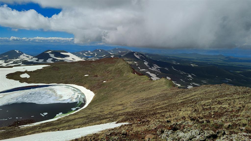 雪の残る山と半ば凍った湖