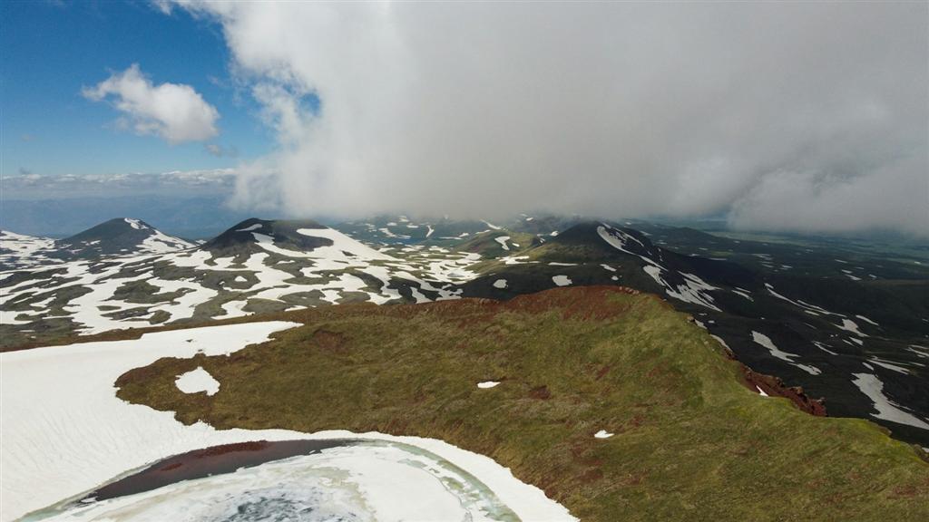 低い雲と雪をまとった険しい山