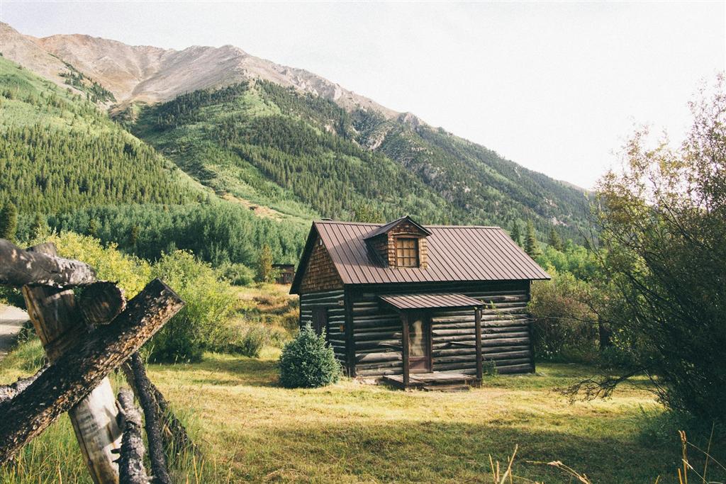 山を背に立つ木造の小屋