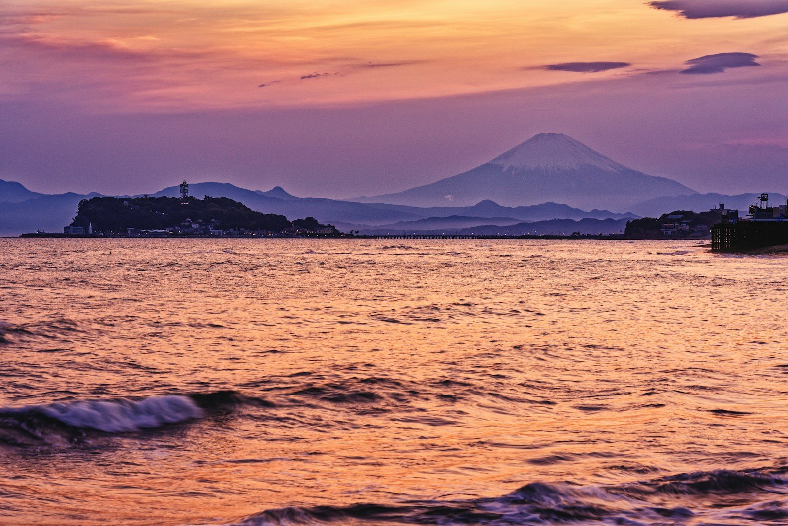 海に沈む夕日と遠くの山