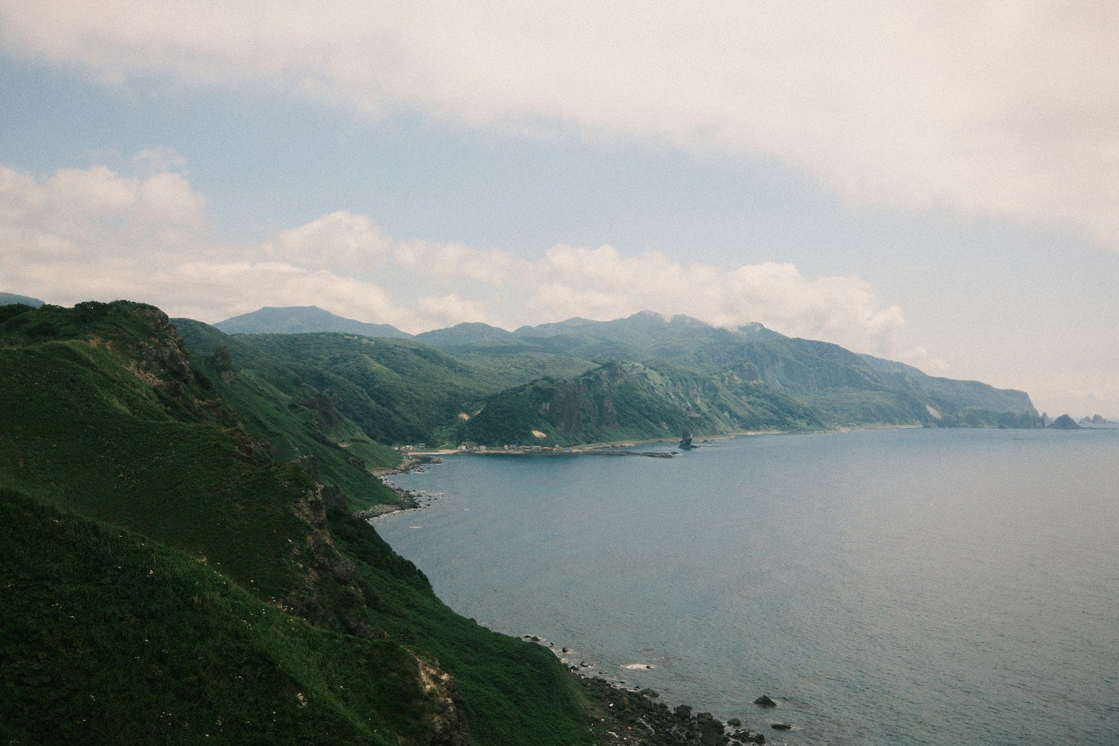 雲の下で海に接する丘