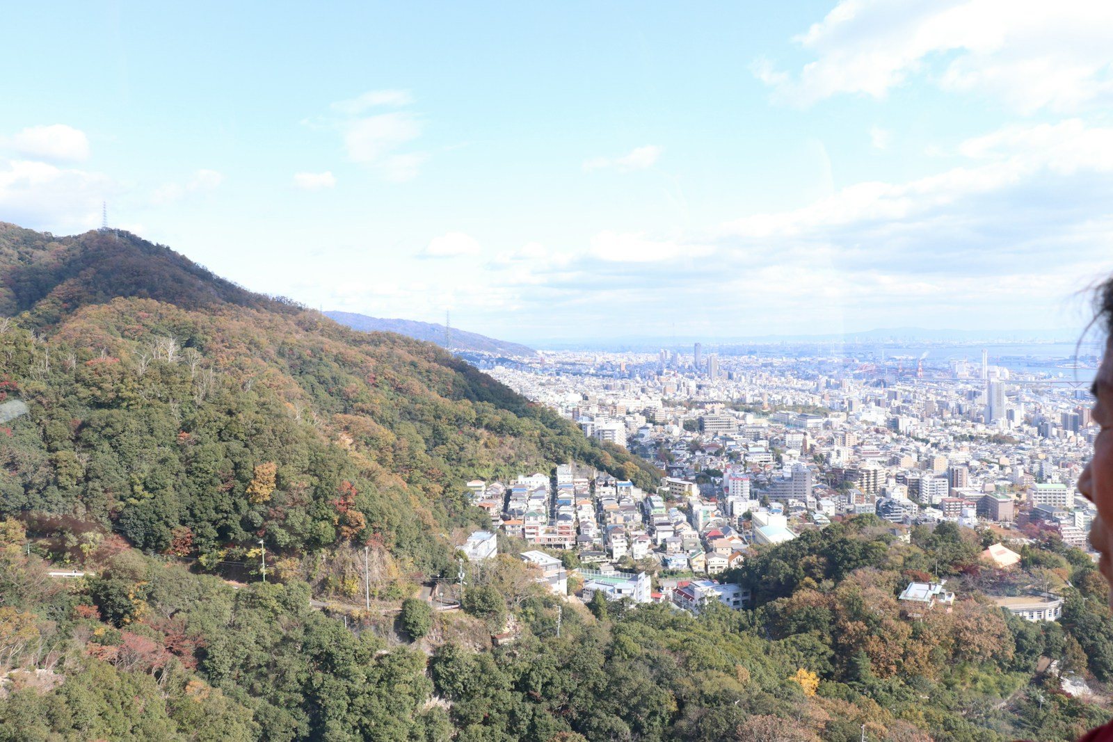 山上の展望台から街を見下ろす登山者