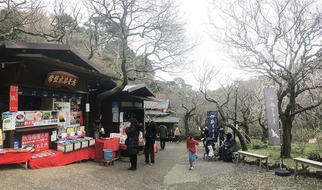 売店ののれんが下がる園内の茶屋と歩く人たち
