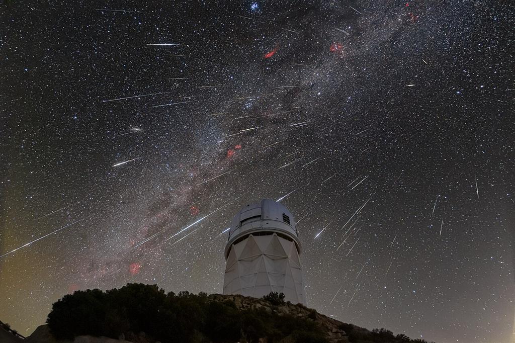 天文台の建物の上に広がる天の川と流れ星
