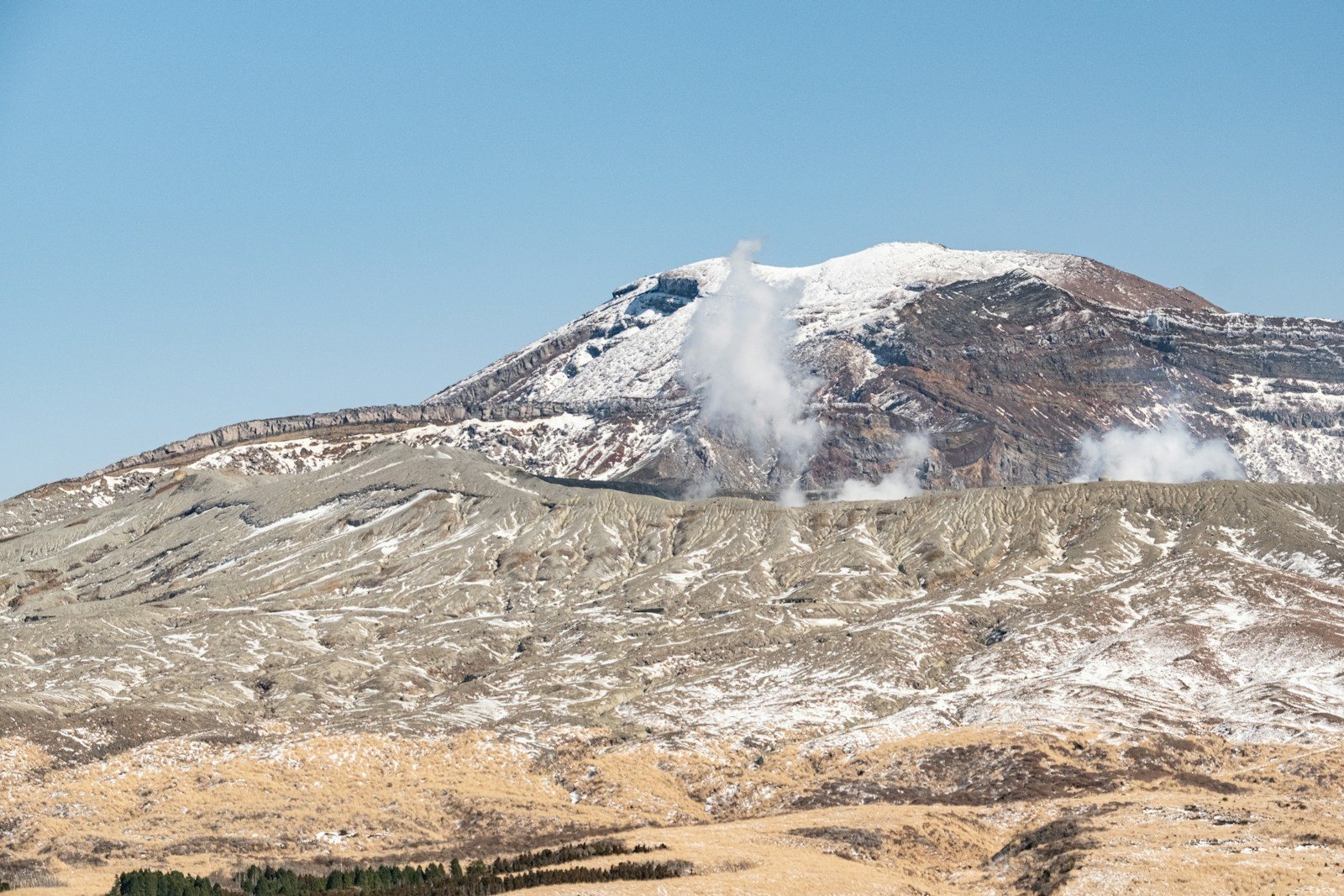 噴気の上がる雪の火山