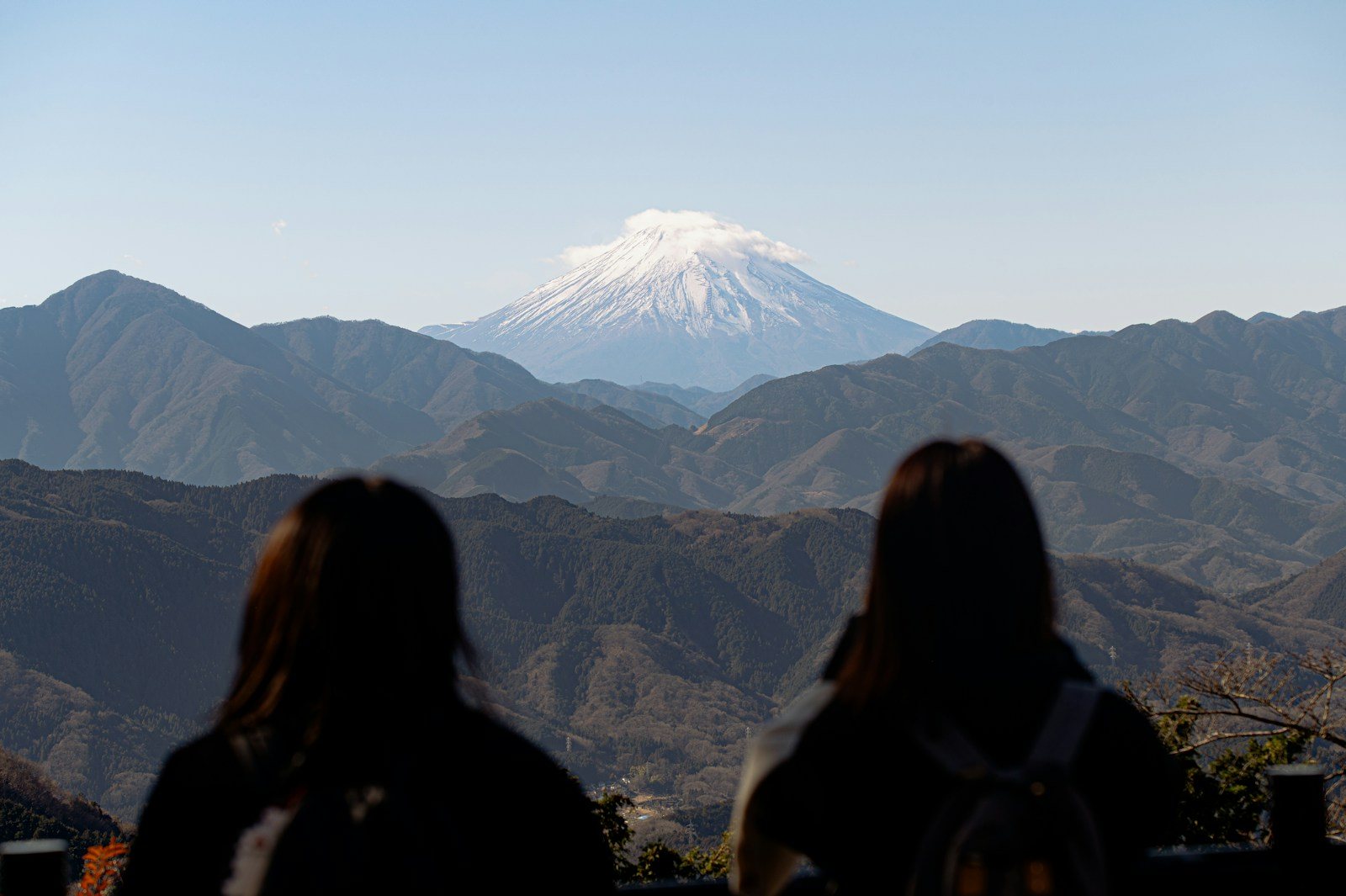 高尾山の山頂から富士山を眺める人